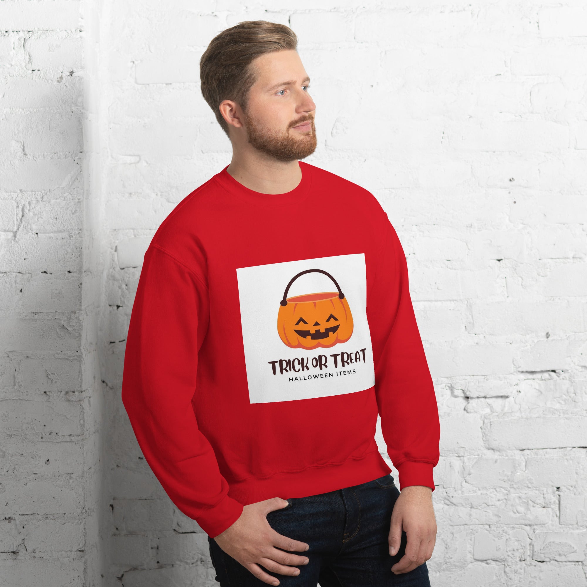 A man wearing a red unisex sweatshirt for winter with a Halloween design featuring a trick or treat pumpkin.